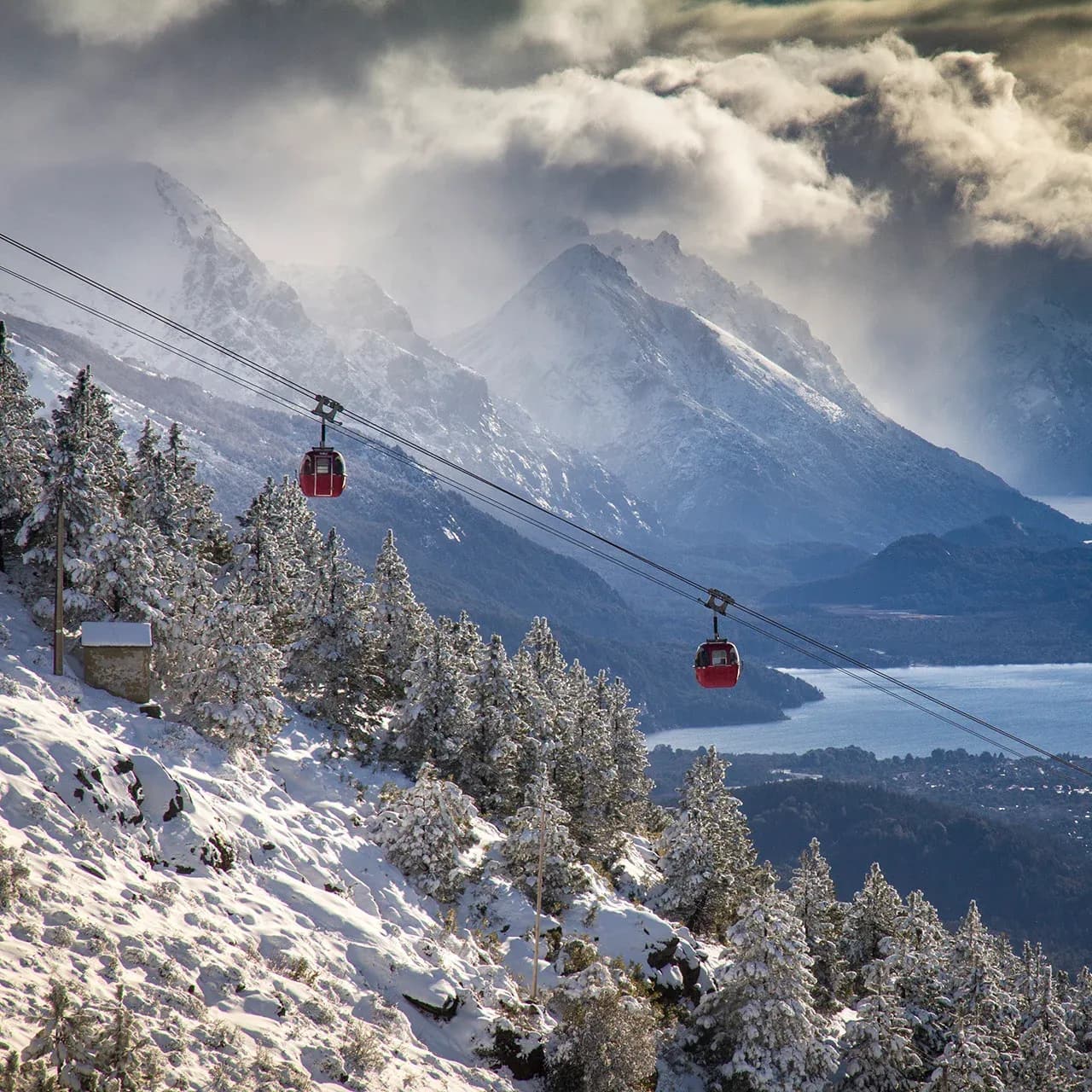 Dos telefericos viajando con el lago Nahuel Huapi de fondo